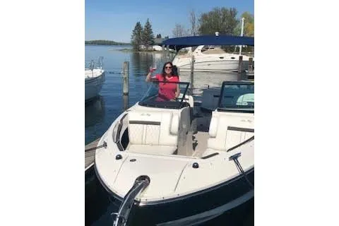 Slide: The Image of 2018 Sea Ray SLX 250 boat docked with a person waving onboard. - 2
