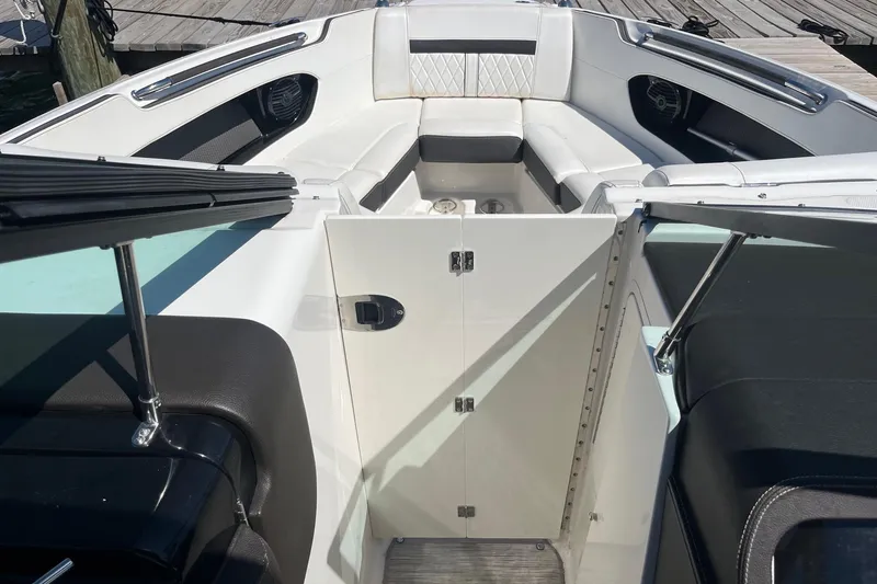 Slide: The Image of 2018 Sea Ray SLX 250 boat interior with white seating and open storage compartment. - 21