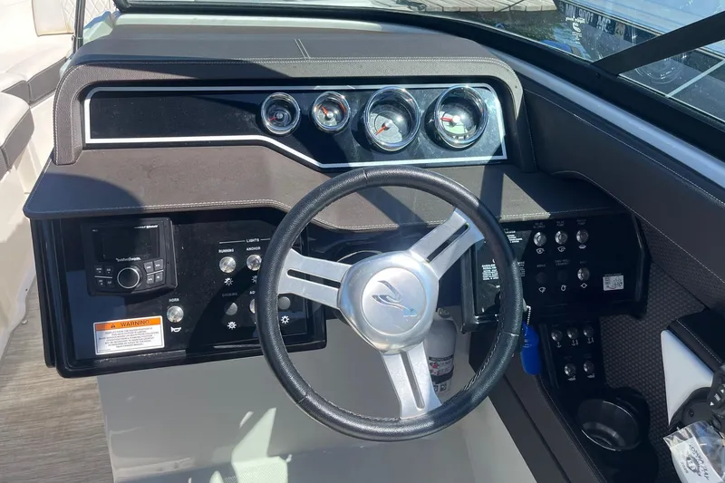 Slide: The Image of 2018 Sea Ray SLX 250 boat dashboard with steering wheel and control panel. - 26