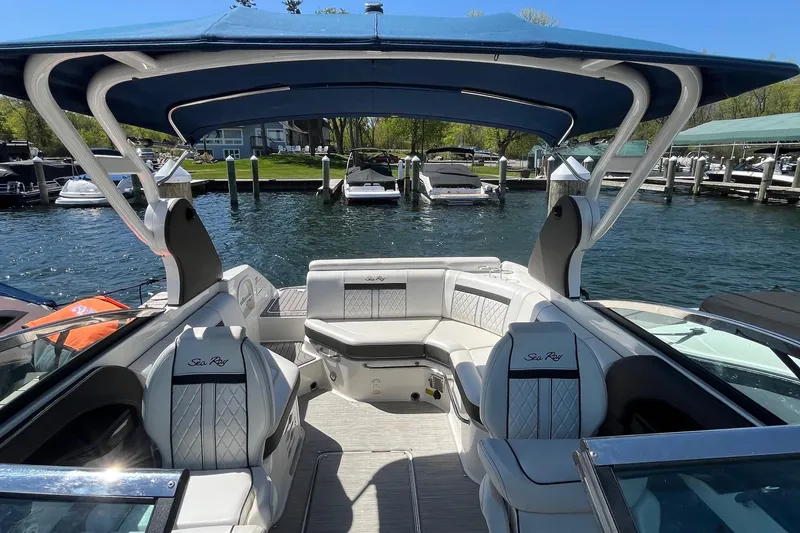 Slide: The Image of 2018 Sea Ray SLX 250 boat interior with luxurious seating and canopy, docked at a marina. - 35