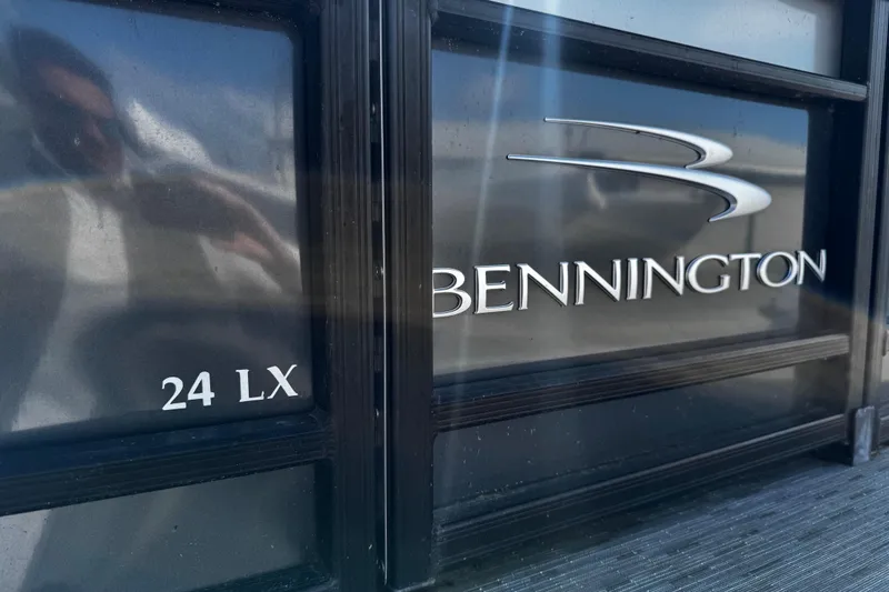 Slide: The Image of 2022 Bennington 24LX boat logo on a sleek black surface. - 11