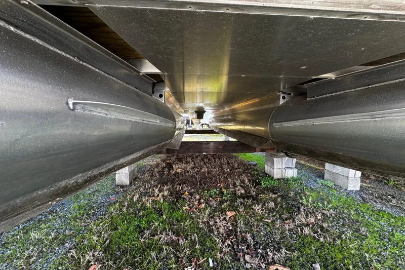 Slide: The Image of Underneath view of a 2022 Bennington 24LX pontoon boat on blocks. - 12