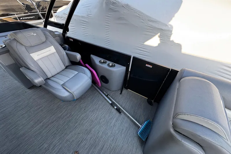 Slide: The Image of Interior of 2022 Bennington 24LX boat with gray seating and cleaning tools. - 4
