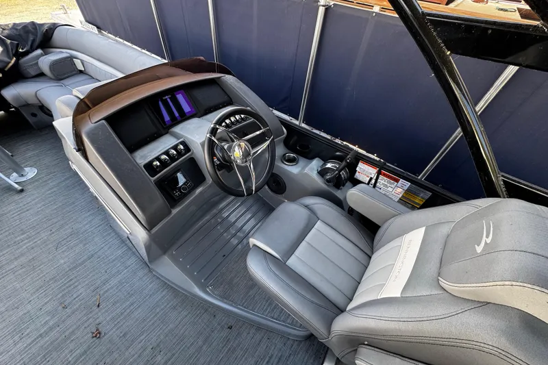 Slide: The Image of 2022 Bennington 24LX boat interior with steering console and plush seating. - 6
