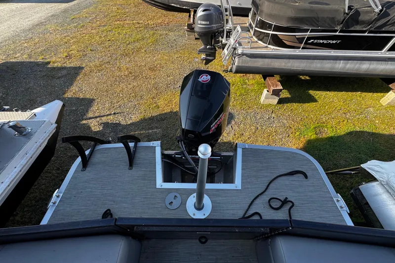 Slide: The Image of 2022 Bennington 24LX pontoon boat with outboard motor, docked on grassy area. - 7
