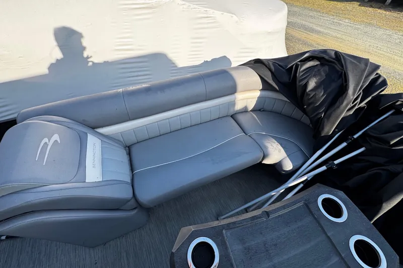 Slide: The Image of 2022 Bennington 24LX boat interior with gray seating and cup holders. - 9