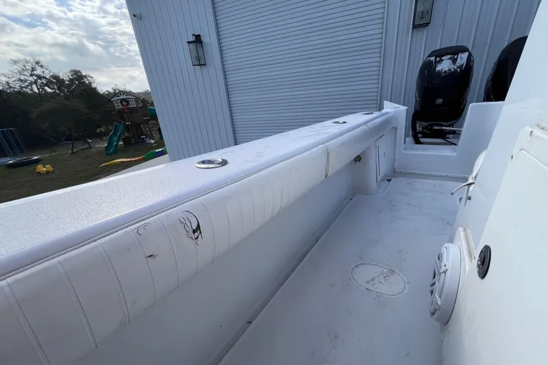 Slide: The Image of 2004 Yellowfin 36 Offshore boat interior with white seating and dual engines. - 49