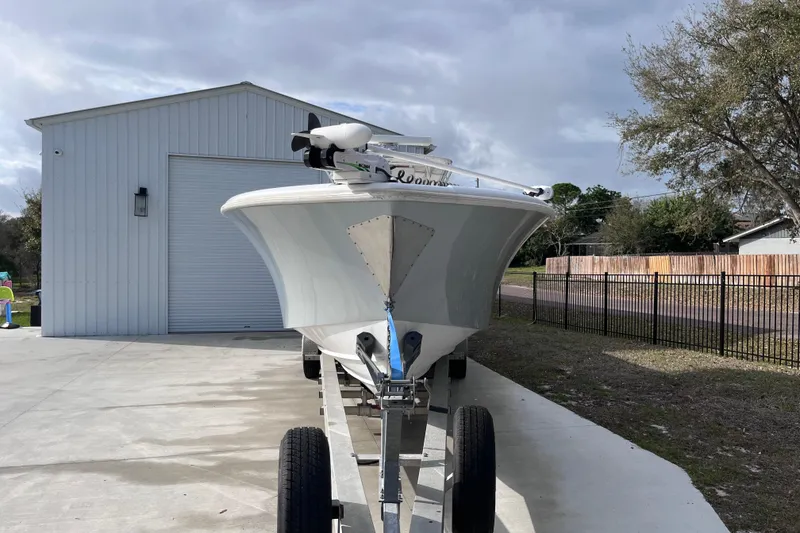 Slide: The Image of 2004 Yellowfin 36 Offshore boat on trailer, parked near a white building. - 7
