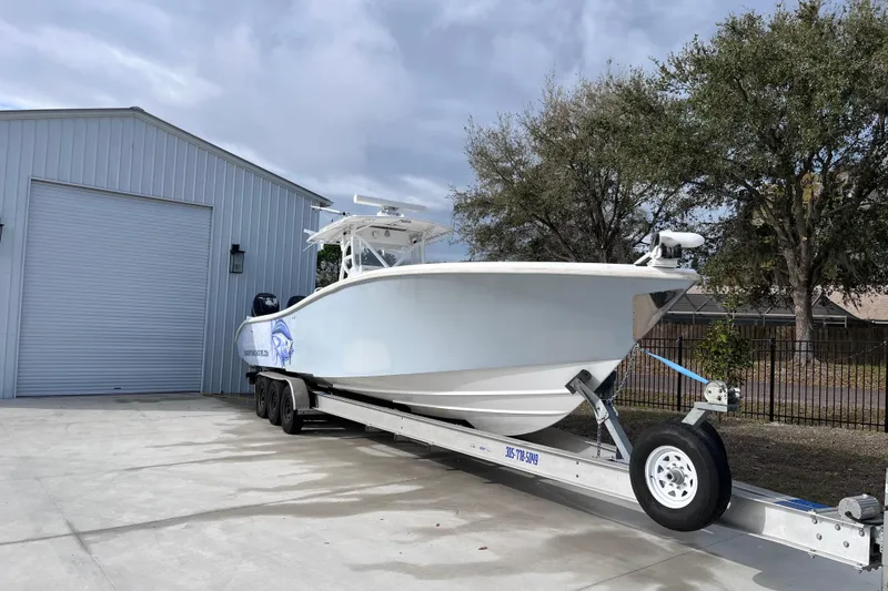 Slide: The Image of 2004 Yellowfin 36 Offshore boat on trailer, parked beside a metal building. - 8