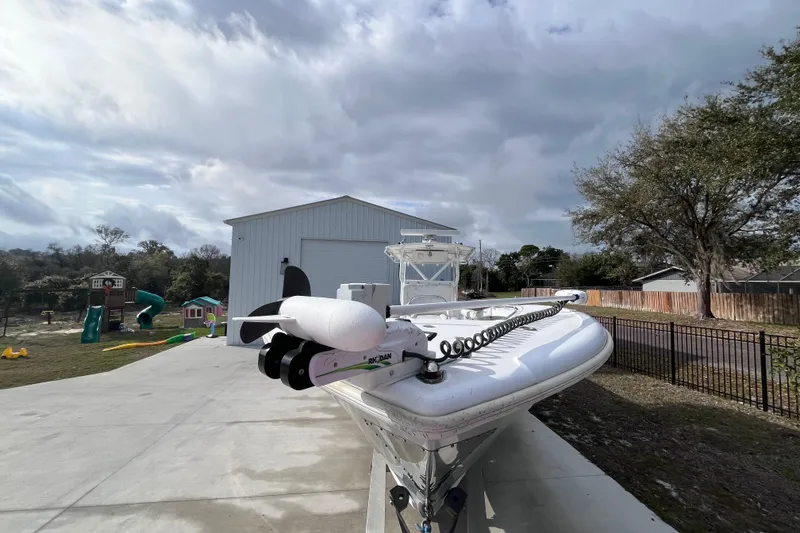 Slide: The Image of 2004 Yellowfin 36 Offshore boat parked on driveway near a large garage. - 9