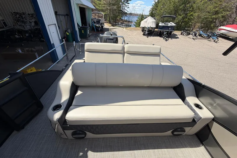 Slide: The Image of 2020 Barletta L25U pontoon boat with beige seating, docked near a lakeside facility. - 15