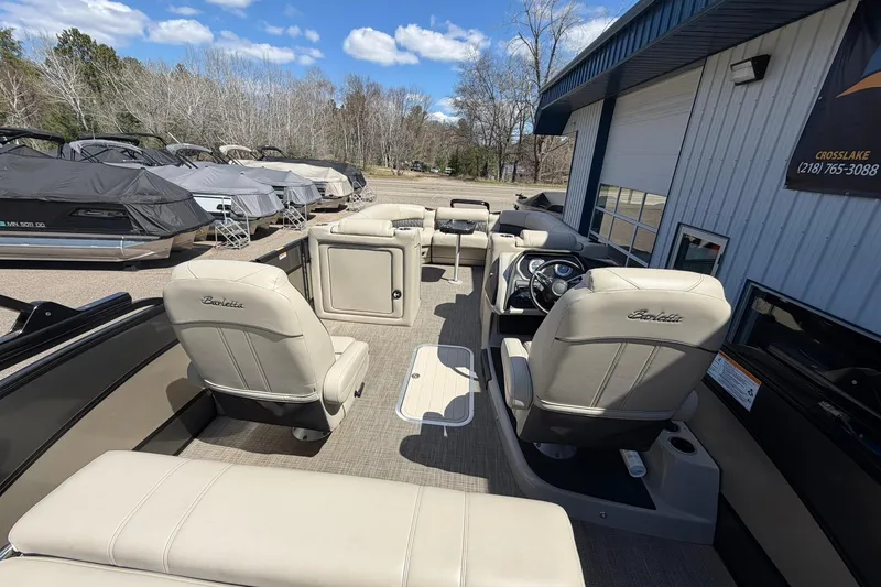 Slide: The Image of 2020 Barletta L25U pontoon boat interior with beige seating and steering console. - 22