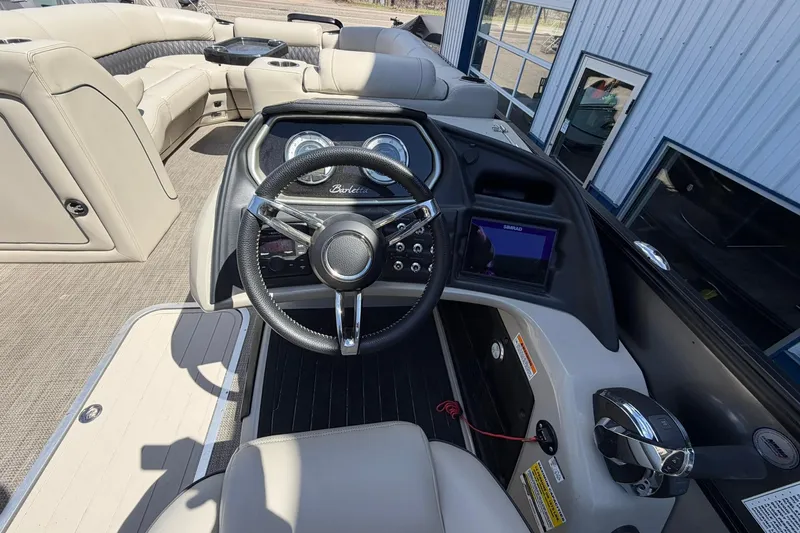 Slide: The Image of Interior view of a 2020 Barletta L25U boat cockpit with steering wheel and controls. - 25