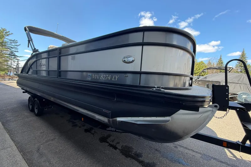Slide: The Image of 2020 Barletta L25U pontoon boat on trailer under clear blue sky. - 5