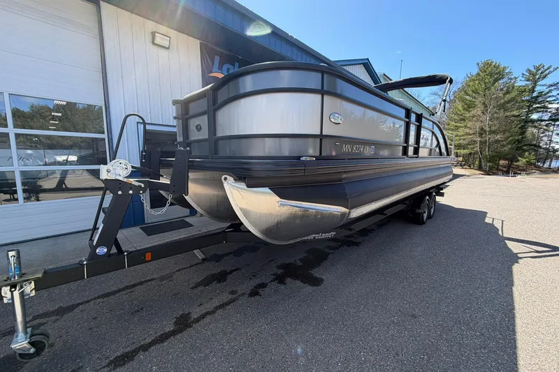 Slide: The Image of 2020 Barletta L25U pontoon boat on trailer, parked outside a building. - 7