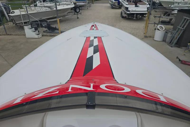 Slide: The Image of 1999 Donzi 28 ZX boat with red and black racing stripes, docked in a marina. - 11