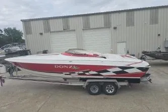 Slide: The Image of 1999 Donzi 28 ZX speedboat with red and white design on a trailer. - 4