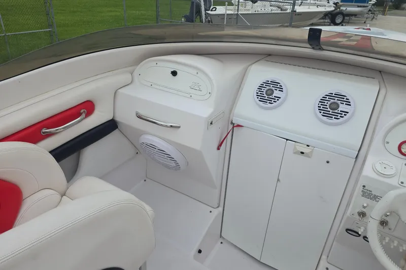 Slide: The Image of Interior of a 1999 Donzi 28 ZX boat featuring white and red seating and dashboard speakers. - 9