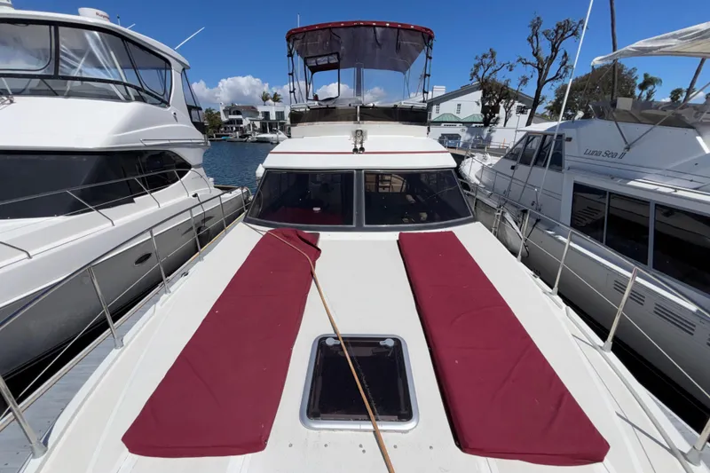 Slide: The Image of 1984 Posillipo Technema yacht docked, featuring red cushions and a clear sky backdrop. - 3