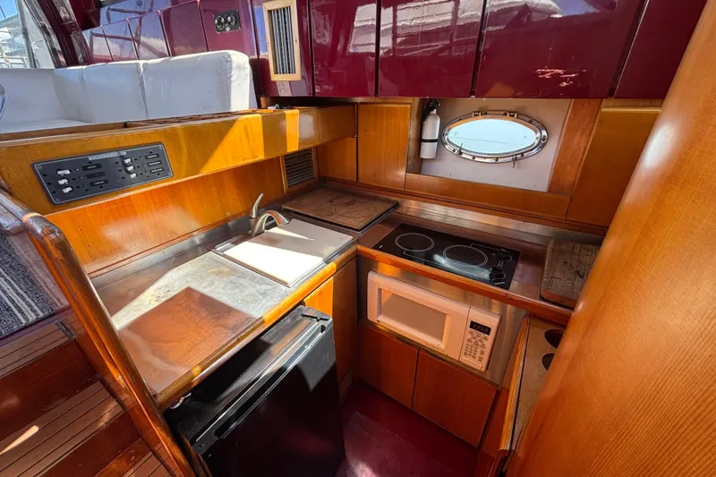 Slide: The Image of 1984 Posillipo Technema yacht kitchen with stove, microwave, and wooden cabinetry. - 7