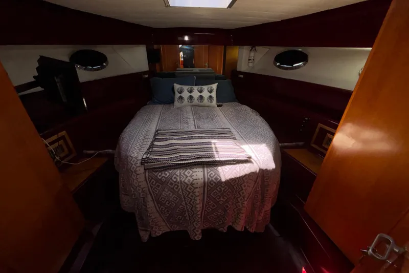 Slide: The Image of Cozy bedroom interior of 1984 Posillipo Technema yacht with patterned bedding and wooden accents. - 9