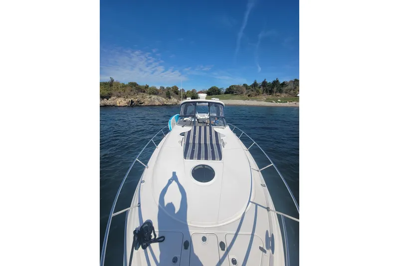 Slide: The Image of 2007 Regal Commodore 3760 IB yacht on calm waters near a scenic shoreline. - 12