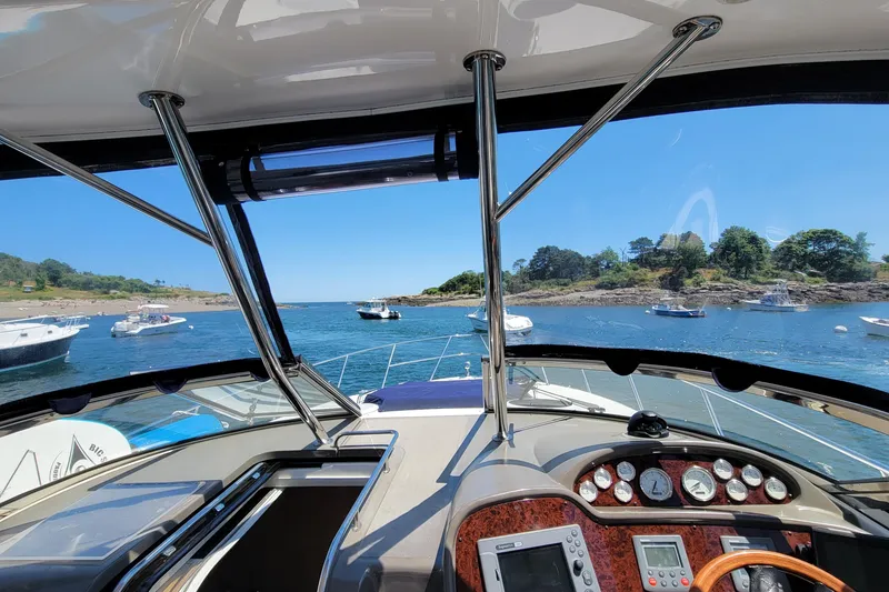 Slide: The Image of 2007 Regal Commodore 3760 IB yacht navigating scenic coastal waters. - 21