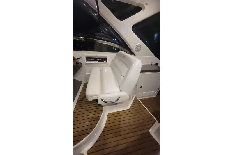 Slide: The Image of Captain's seat on 2007 Regal Commodore 3760 IB yacht, featuring sleek white design and wood flooring. - 25