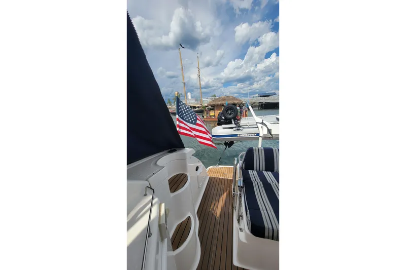 Slide: The Image of 2007 Regal Commodore 3760 IB yacht with American flag, docked under cloudy sky. - 30