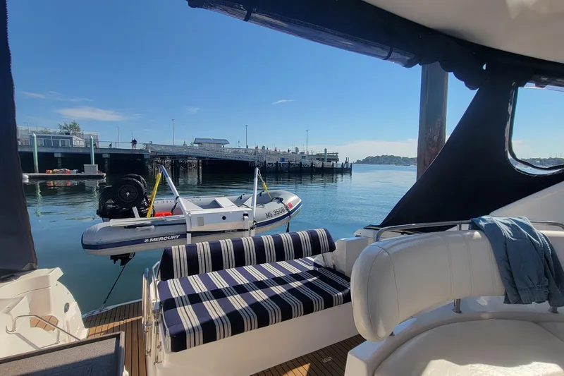 Slide: The Image of 2007 Regal Commodore 3760 IB yacht interior with striped seating, docked by a calm waterfront. - 35