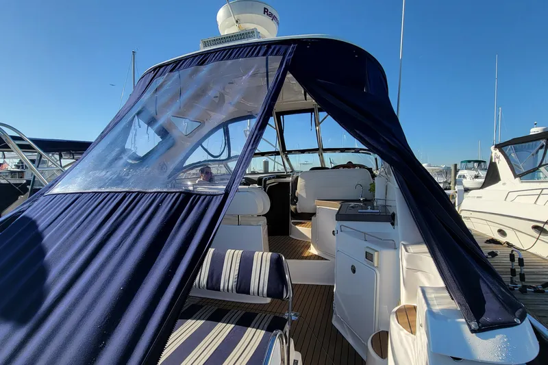 Slide: The Image of 2007 Regal Commodore 3760 IB yacht with blue canopy, docked under clear skies. - 37
