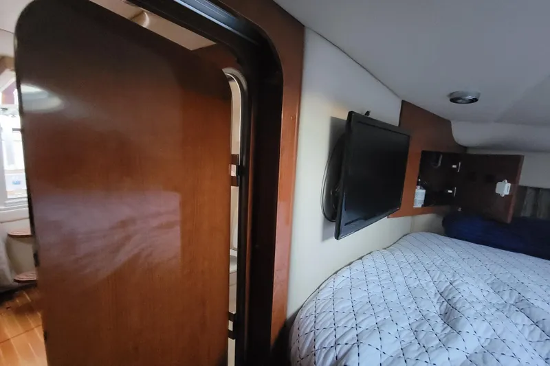 Slide: The Image of Interior of 2007 Regal Commodore 3760 IB yacht with bed, TV, and wooden door. - 4