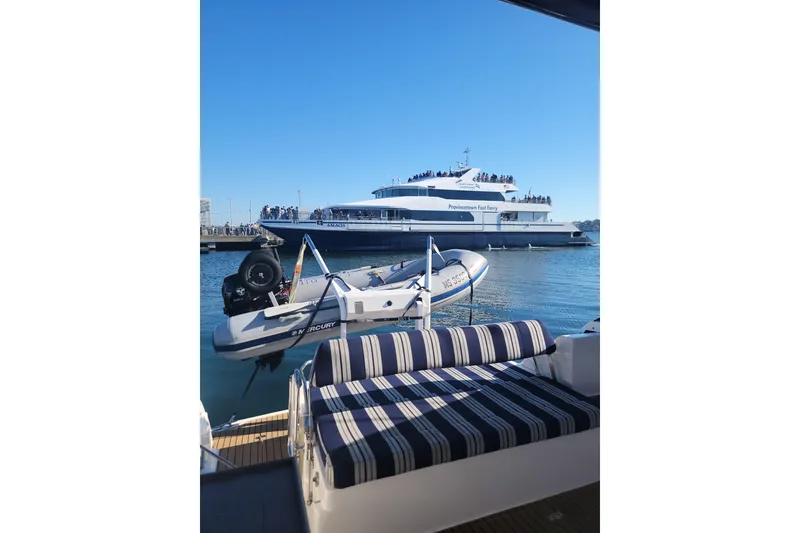 Slide: The Image of 2007 Regal Commodore 3760 IB with striped seating, docked near a ferry on a sunny day. - 41