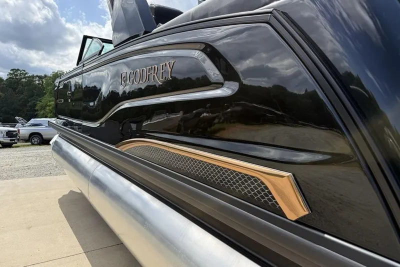 Slide: The Image of 2026 Godfrey Sanpan 2700 ULW Twin pontoon boat with sleek black design and gold accents. - 14