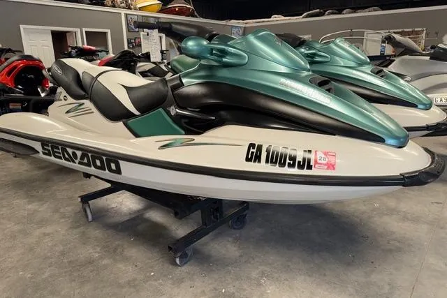 The Image of 2001 Sea-Doo GTX jet ski in showroom, featuring sleek design and green accents. - 1