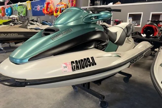 Slide: The Image of 2001 Sea-Doo GTX jet ski in showroom, green and white design, displayed indoors. - 3