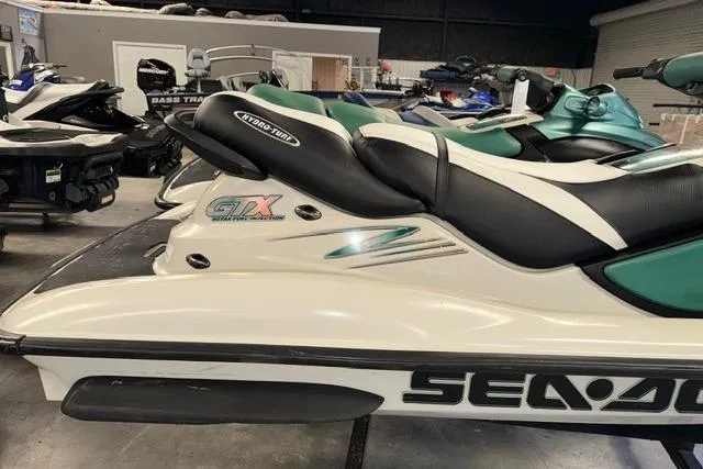 Slide: The Image of 2001 Sea-Doo GTX jet ski in showroom, featuring sleek design and comfortable seating. - 5