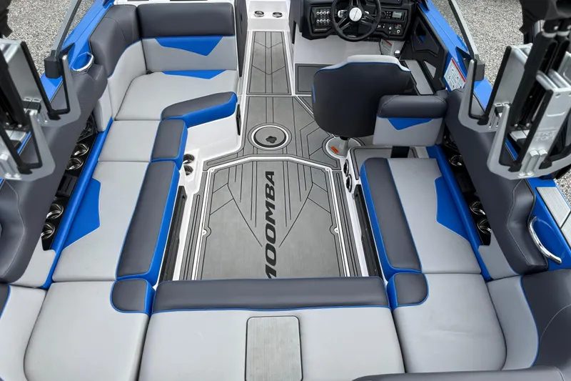 Slide: The Image of Interior of 2021 Moomba Kaiyen boat with blue and gray seating and modern dashboard. - 11