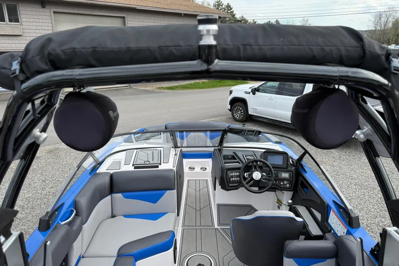 Slide: The Image of 2021 Moomba Kaiyen boat interior with modern dashboard and seating, parked outdoors. - 12