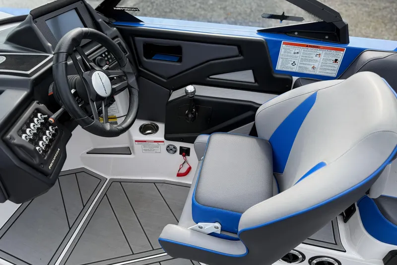 Slide: The Image of 2021 Moomba Kaiyen boat interior with steering wheel and blue-accented captain's seat. - 16