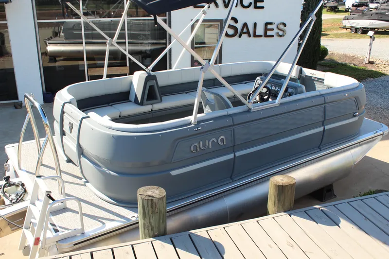 Slide: The Image of 2026 Tahoe Pontoon Aura boat displayed at a sales service location. - 13