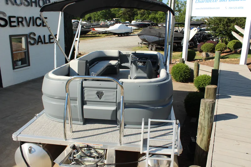 Slide: The Image of 2026 Tahoe Pontoon Aura boat displayed at a dealership with a sleek, modern design. - 14