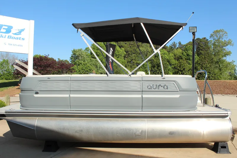 Slide: The Image of 2026 Tahoe Pontoon Aura boat with canopy, displayed outdoors on a sunny day. - 16