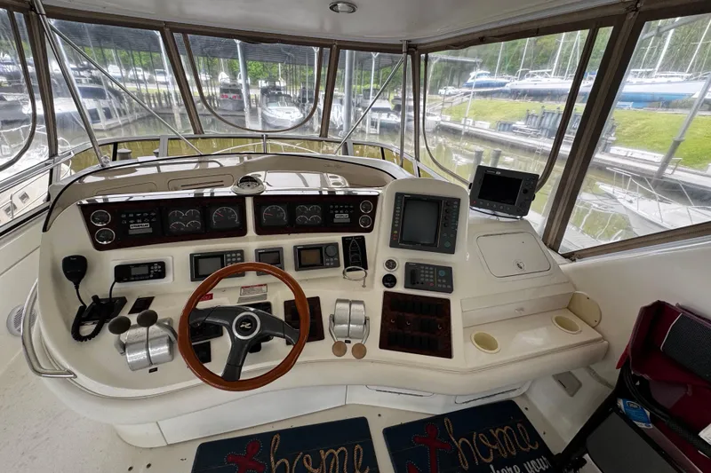 Slide: The Image of 1999 Sea Ray 480 Sedan Bridge helm with navigation instruments and steering wheel. - 16