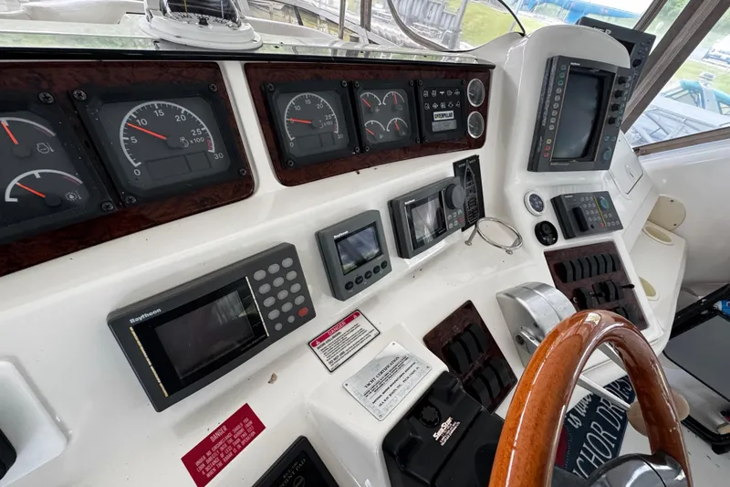 Slide: The Image of 1999 Sea Ray 480 Sedan Bridge helm with gauges, controls, and navigation equipment. - 18