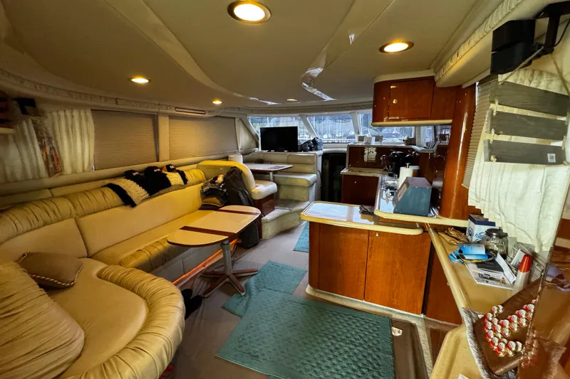 Slide: The Image of Luxurious interior of a 1999 Sea Ray 480 Sedan Bridge yacht with cozy seating and wooden cabinetry. - 21