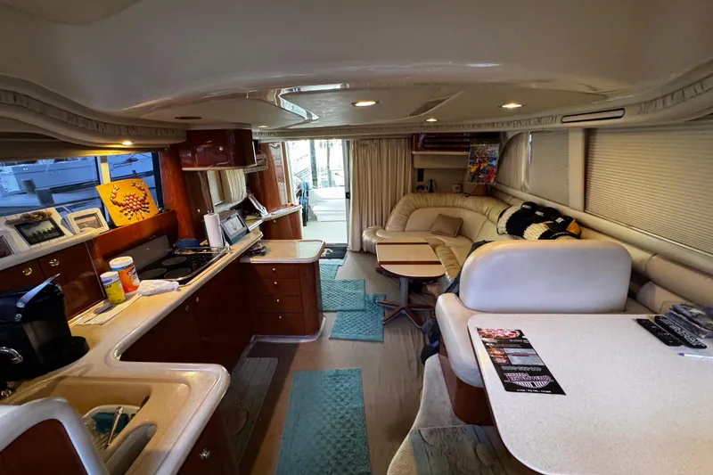 Slide: The Image of Interior of a 1999 Sea Ray 480 Sedan Bridge yacht, featuring a cozy living area and kitchen. - 24