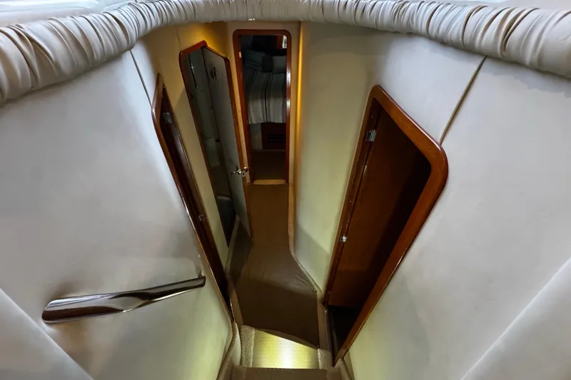 Slide: The Image of Interior hallway of a 1999 Sea Ray 480 Sedan Bridge yacht, featuring elegant wood finishes. - 26