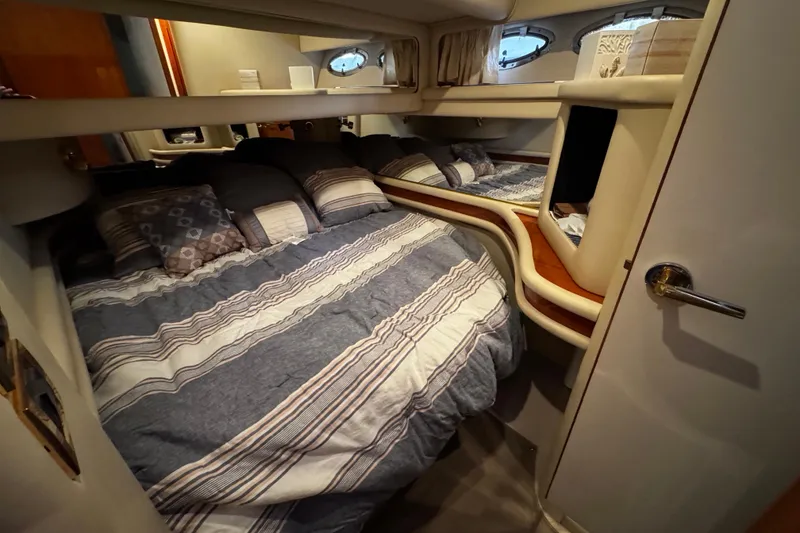 Slide: The Image of Cozy bedroom interior of 1999 Sea Ray 480 Sedan Bridge yacht with striped bedding. - 29