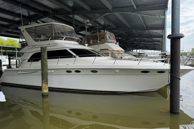 The Image of 1999 Sea Ray 480 Sedan Bridge yacht docked in a covered marina. - 3